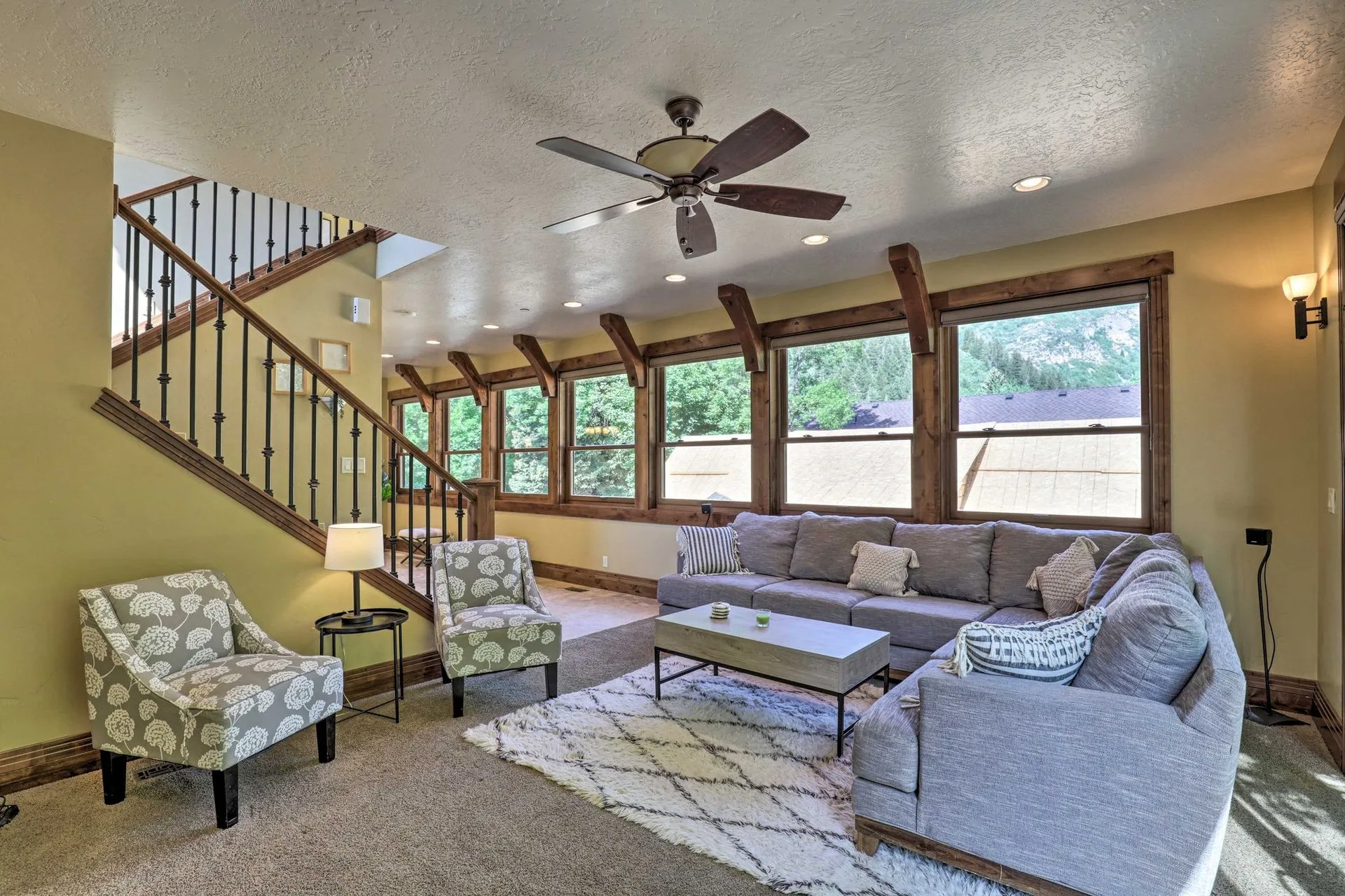 Great room with vaulted timber-beam ceiling, sectional sofa, and canyon-view windows